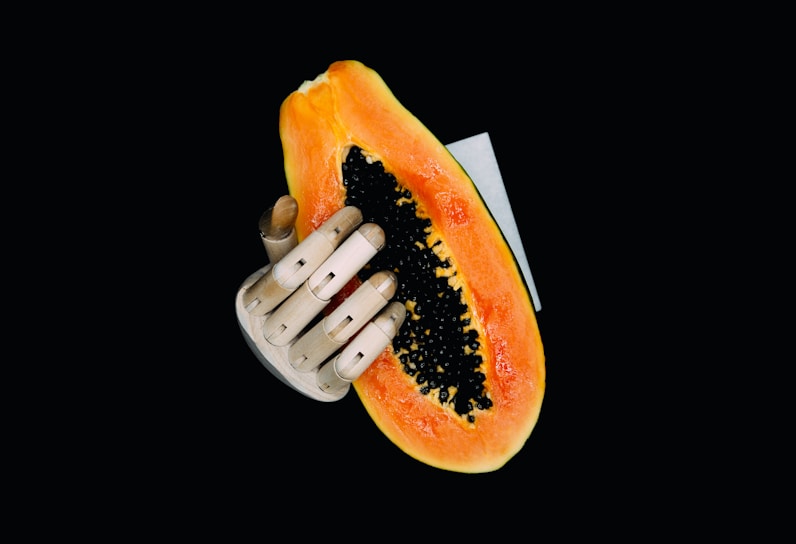 Wooden hand holding orange and yellow fruit, representing vitality, desire, and women’s sexual healt