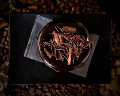 brown and white coffee beans on black paper