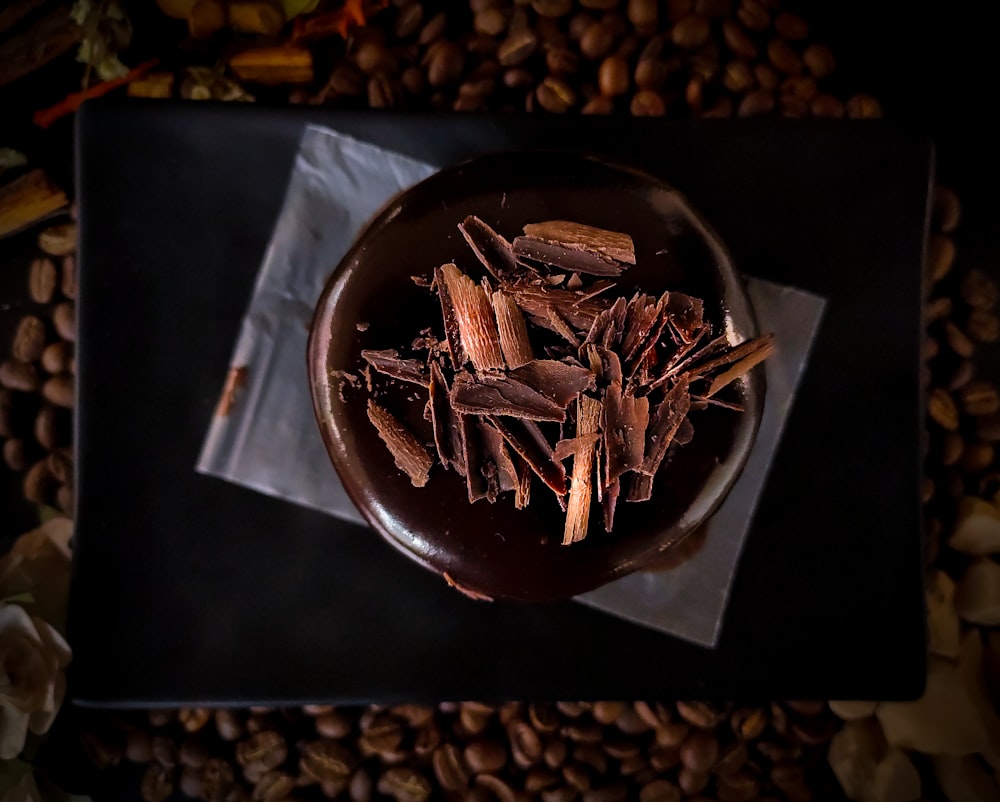 brown and white coffee beans on black paper