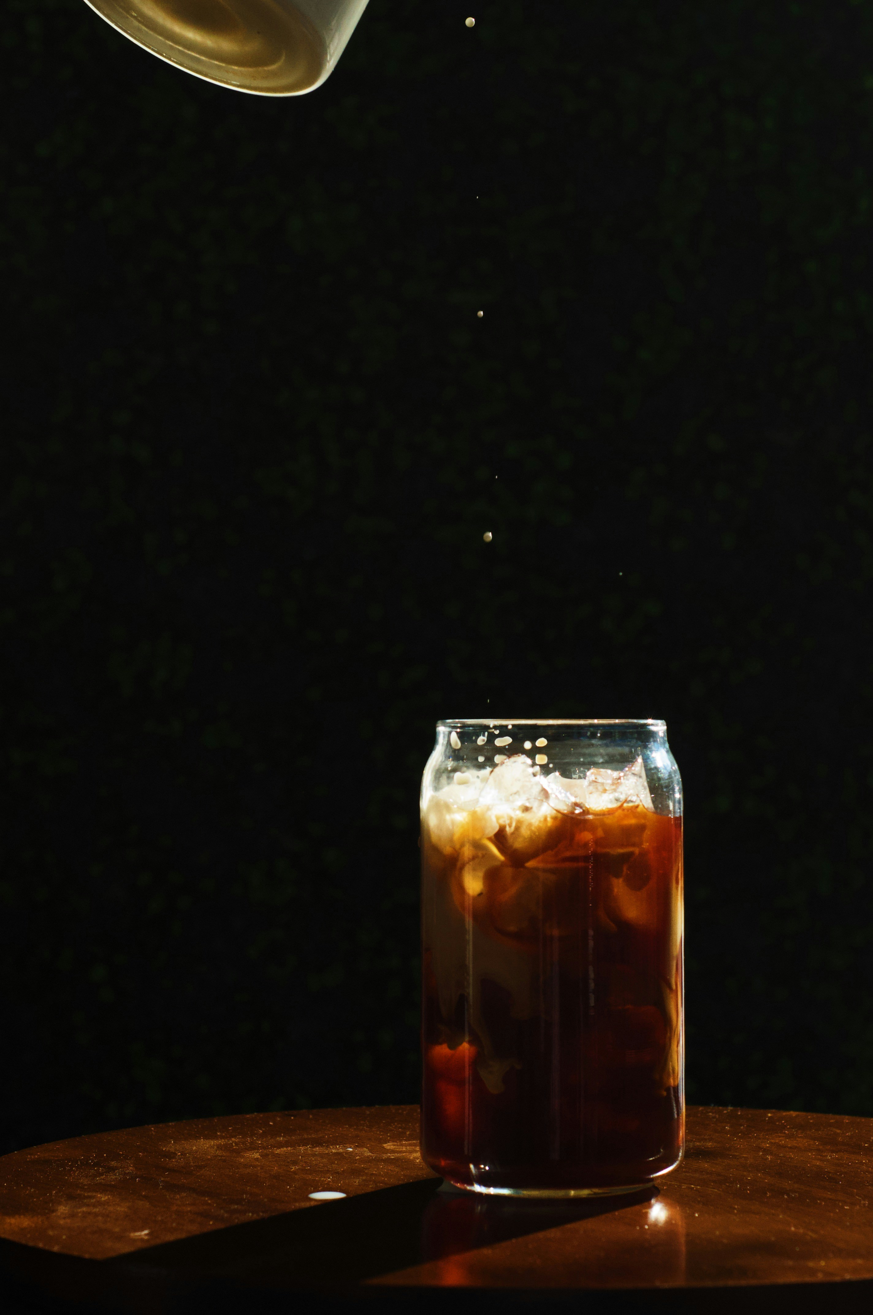 茶色の液体が入った透明なコップ