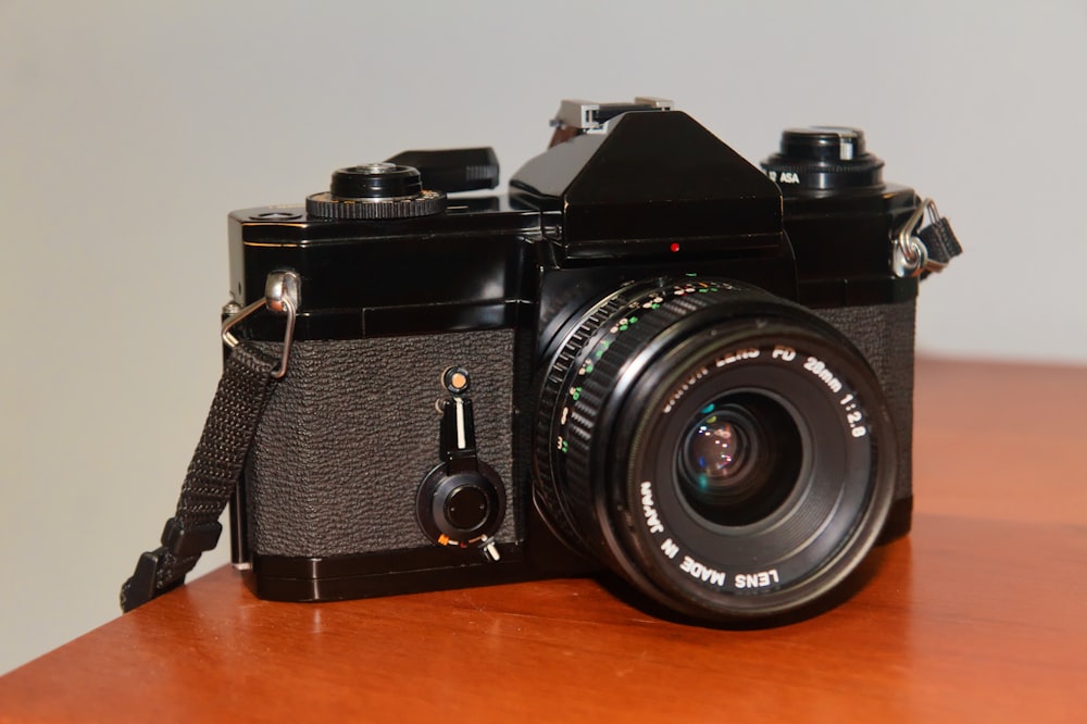 black nikon dslr camera on brown wooden table