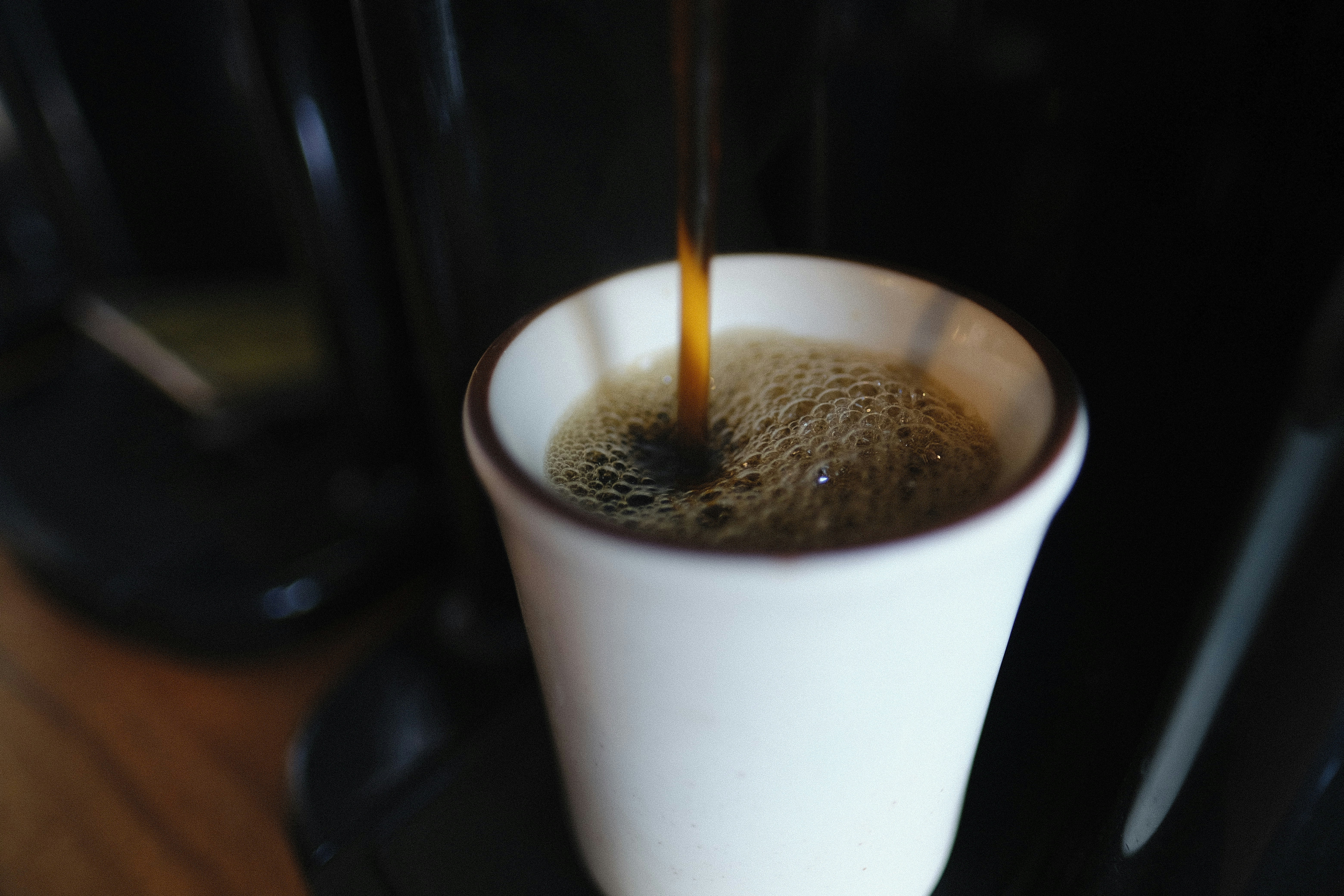 white paper cup with brown liquid