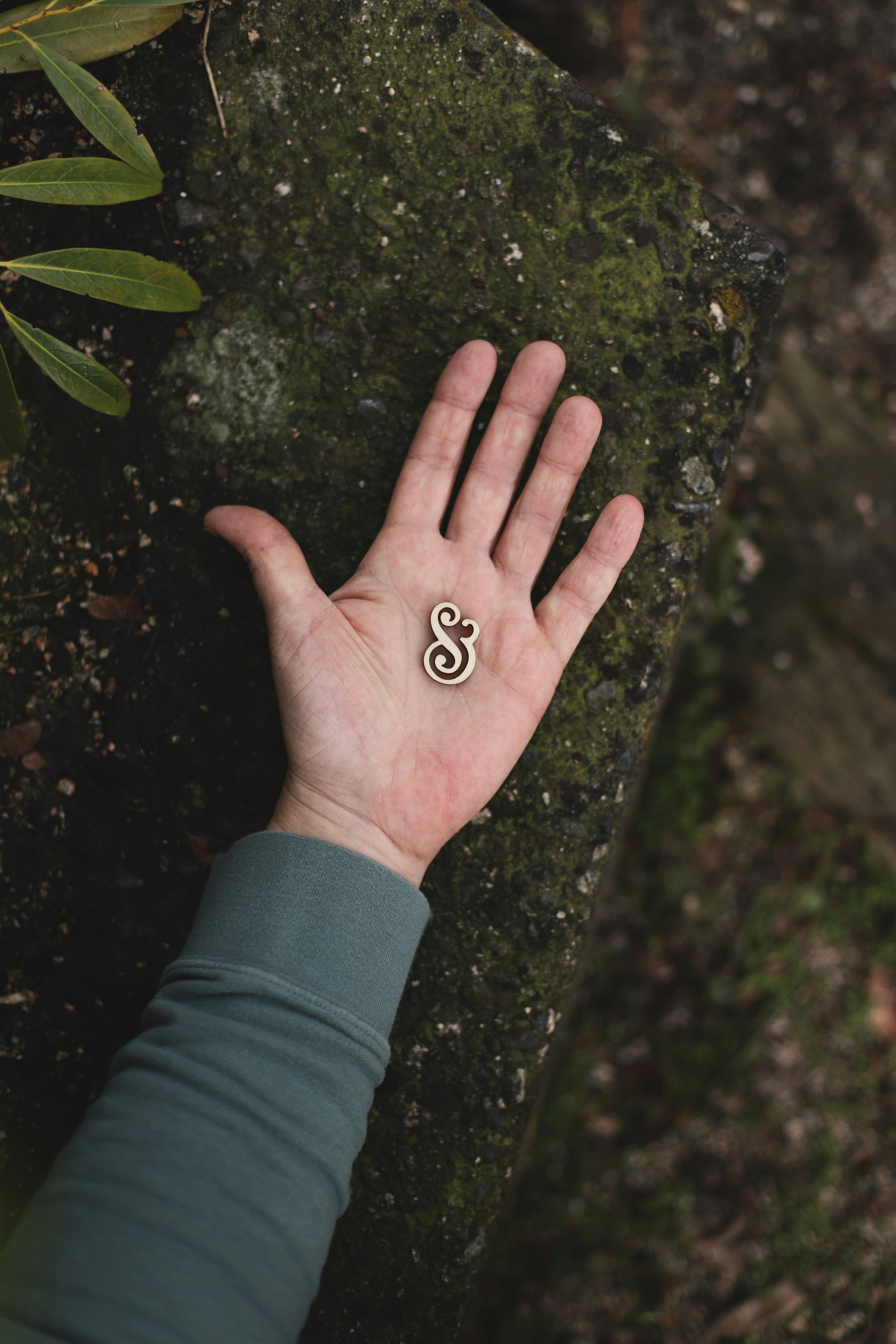 Persona con tatuaje de corazón negro en la mano izquierda