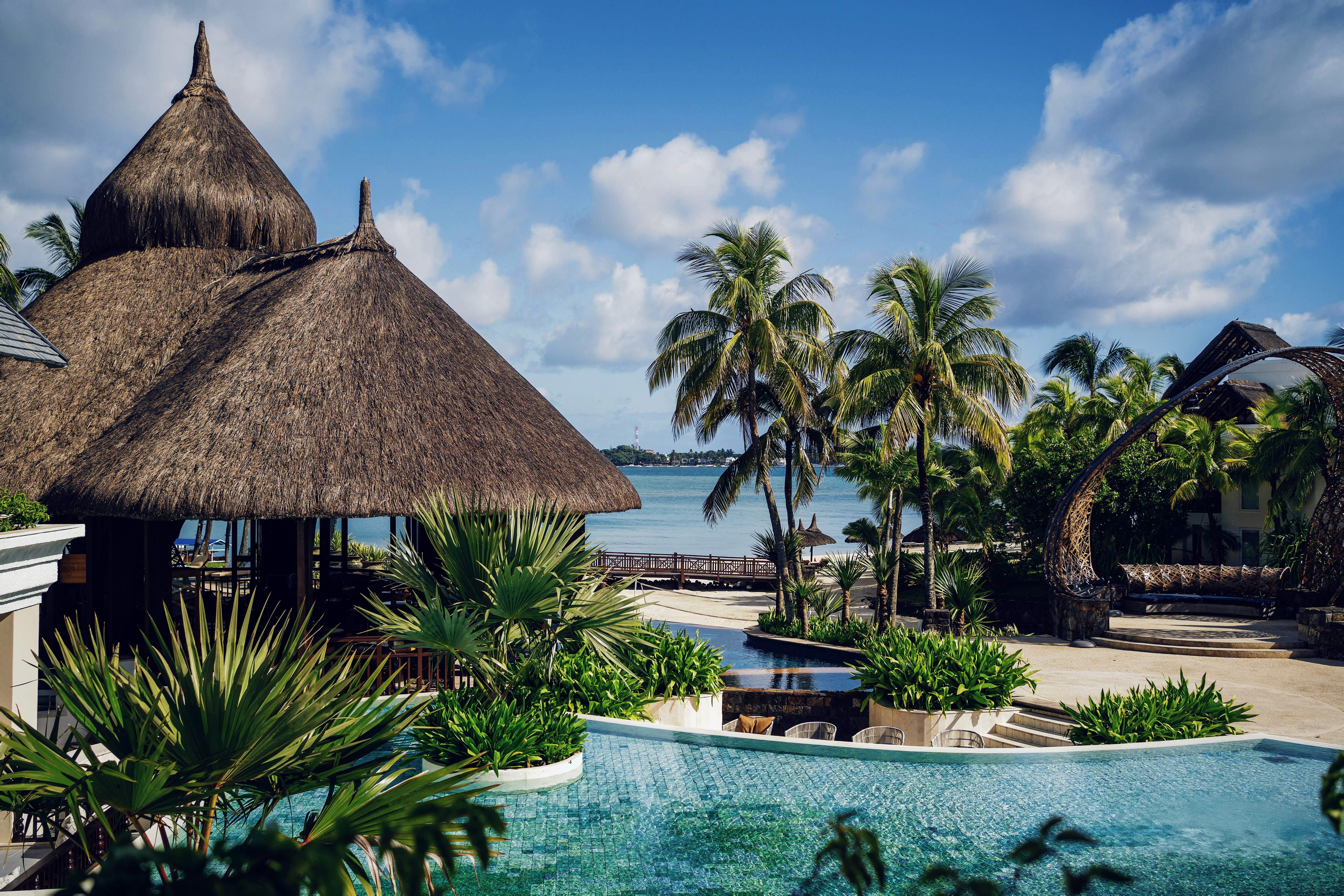 brown nipa hut near swimming pool during daytime