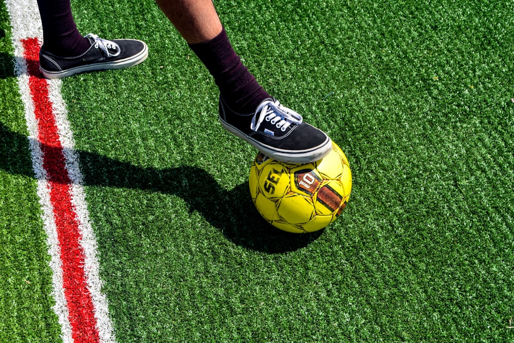 yellow and black soccer ball on green grass field