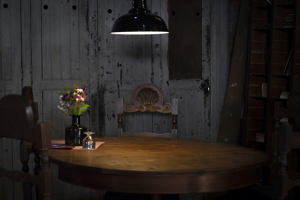 black pendant lamp turned on near brown wooden table