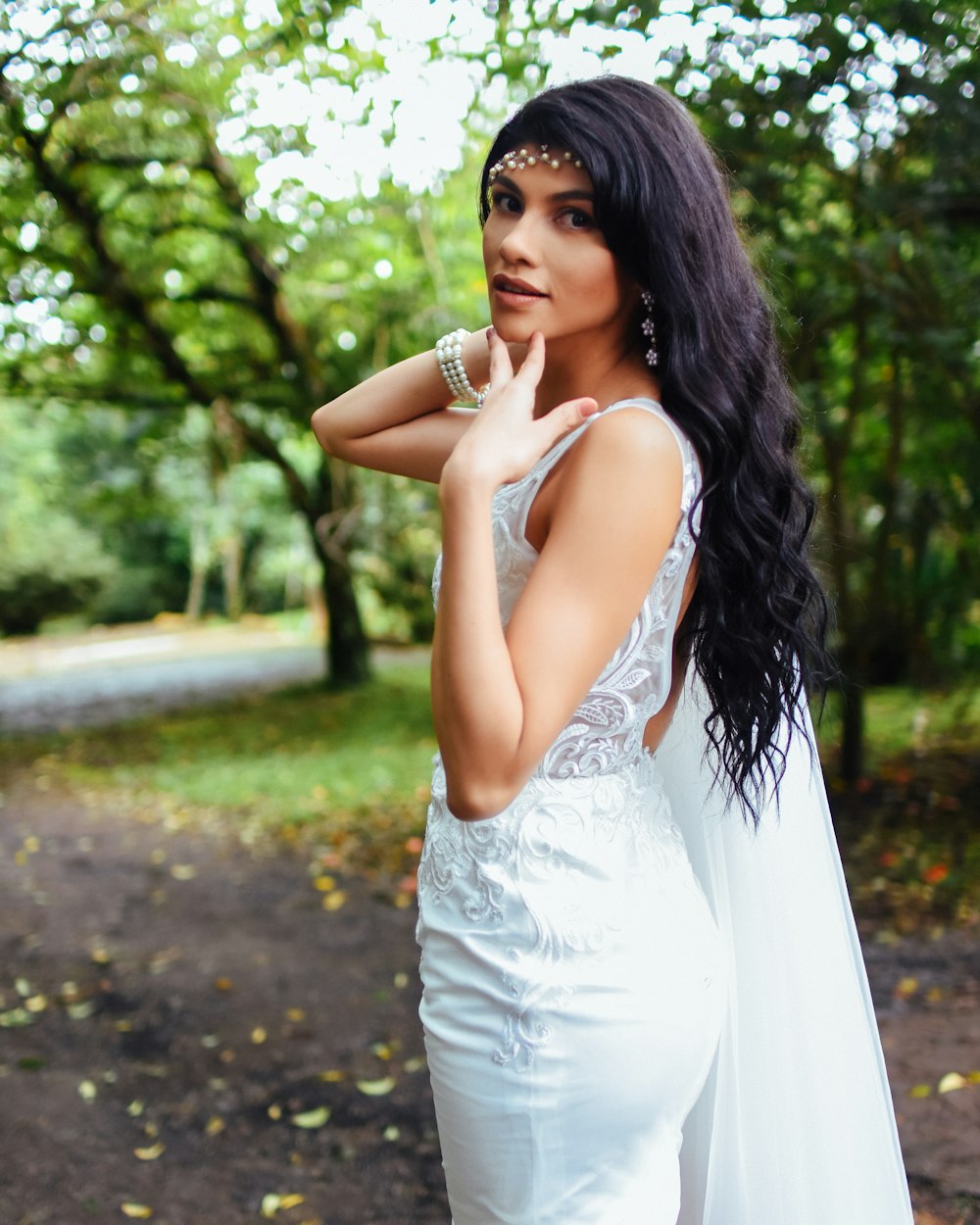 femme en robe blanche sans manches debout sur la route pendant la journée