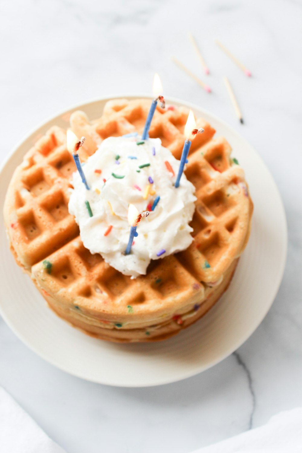 brown waffle with white cream on white ceramic plate