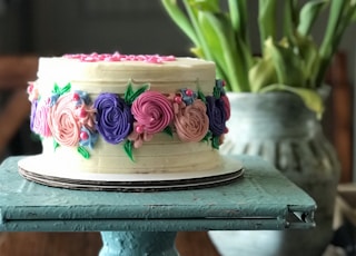 pink and white floral cake on black stand