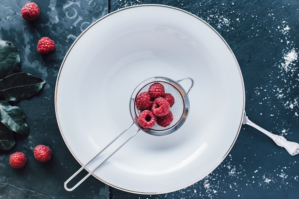 red raspberry on white ceramic bowl