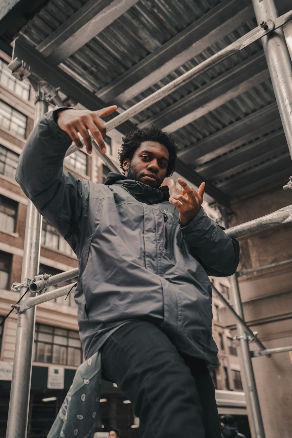 man in black jacket raising his hands