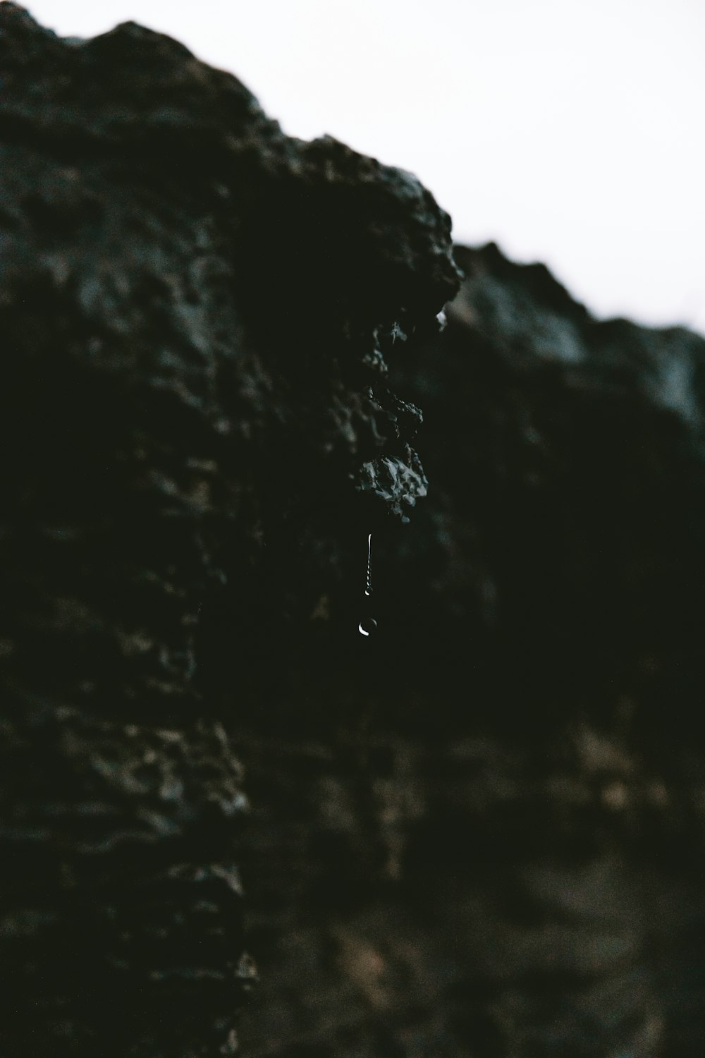 person in black jacket standing on rock formation during daytime