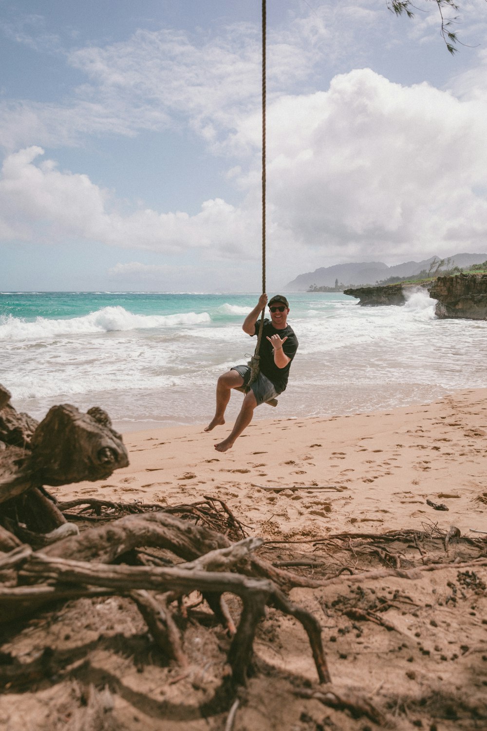 woman in black tank top and black shorts jumping on beach during daytime