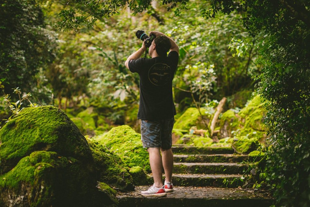 man in black t-shirt and blue denim shorts standing on stairs