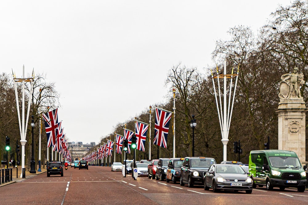 cars parked on the side of the road with flags on the side during daytime