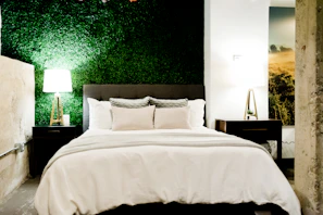 Elegant bedroom featuring terracotta accents and emerald green cushions.