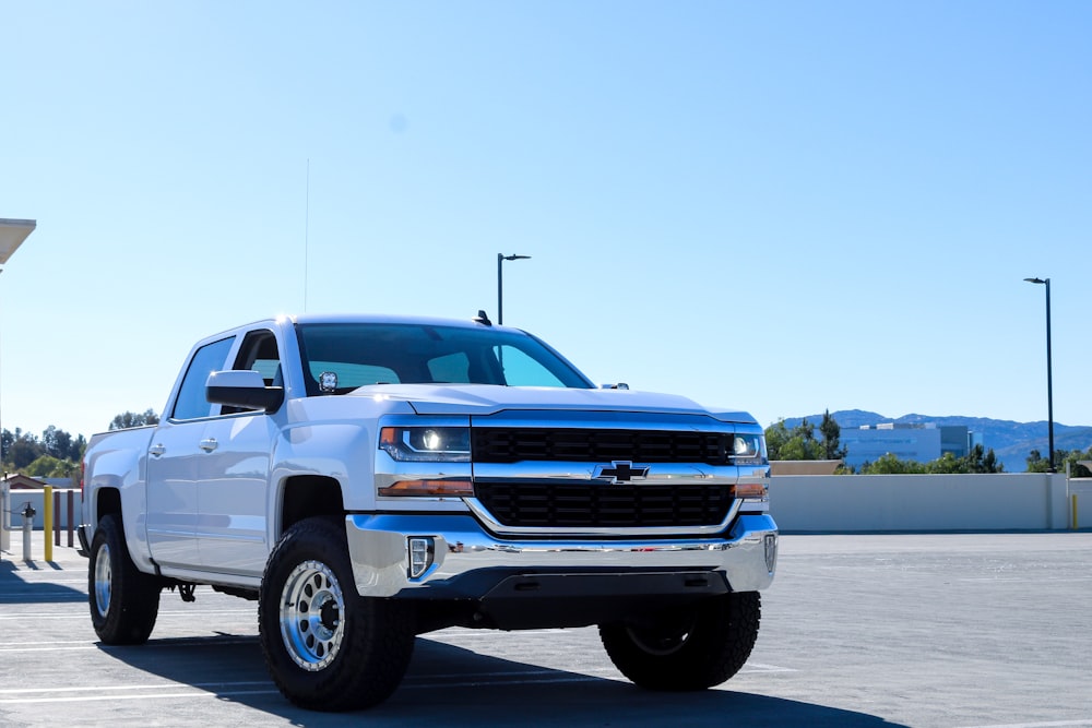 blue chevrolet crew cab pickup truck on gray concrete road during daytime