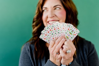 woman in gray cardigan holding white and pink floral print umbrella