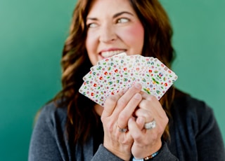 woman in gray cardigan holding white and pink floral print umbrella