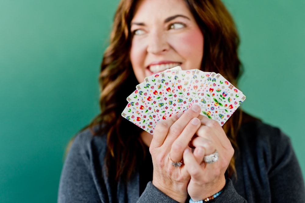 woman in gray cardigan holding white and pink floral print umbrella