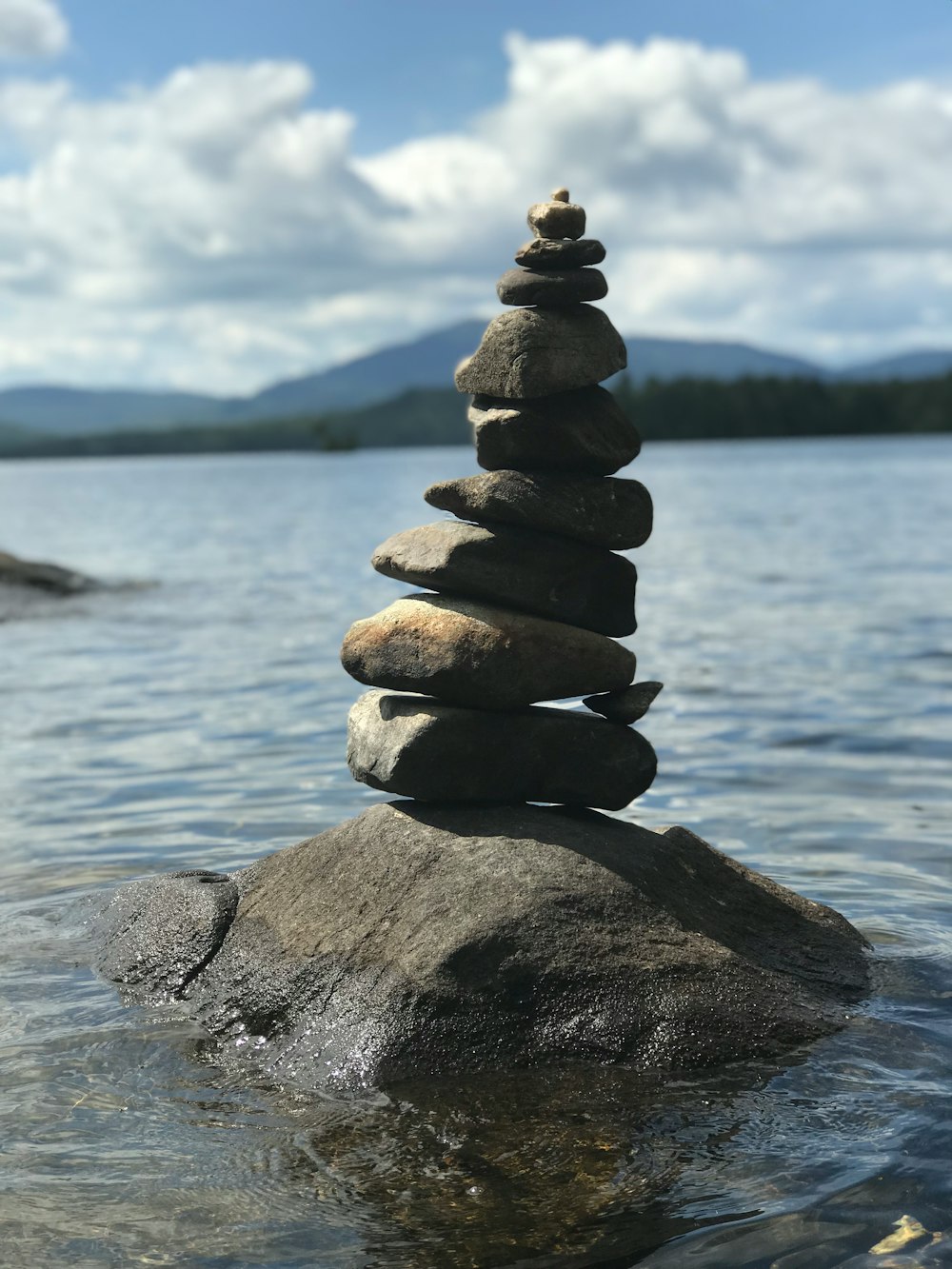 stack of stones near body of water during daytime