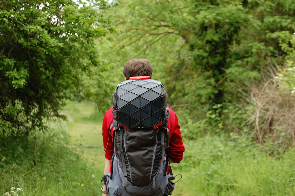 man in red jacket carrying black and gray backpack