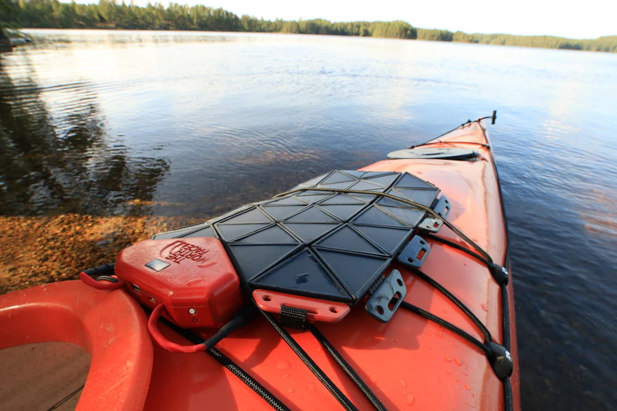 Waterproof gear bag secured to the back deck of a kayak before launch