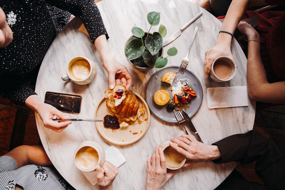 Person, die weiße Keramikplatte mit Essen hält