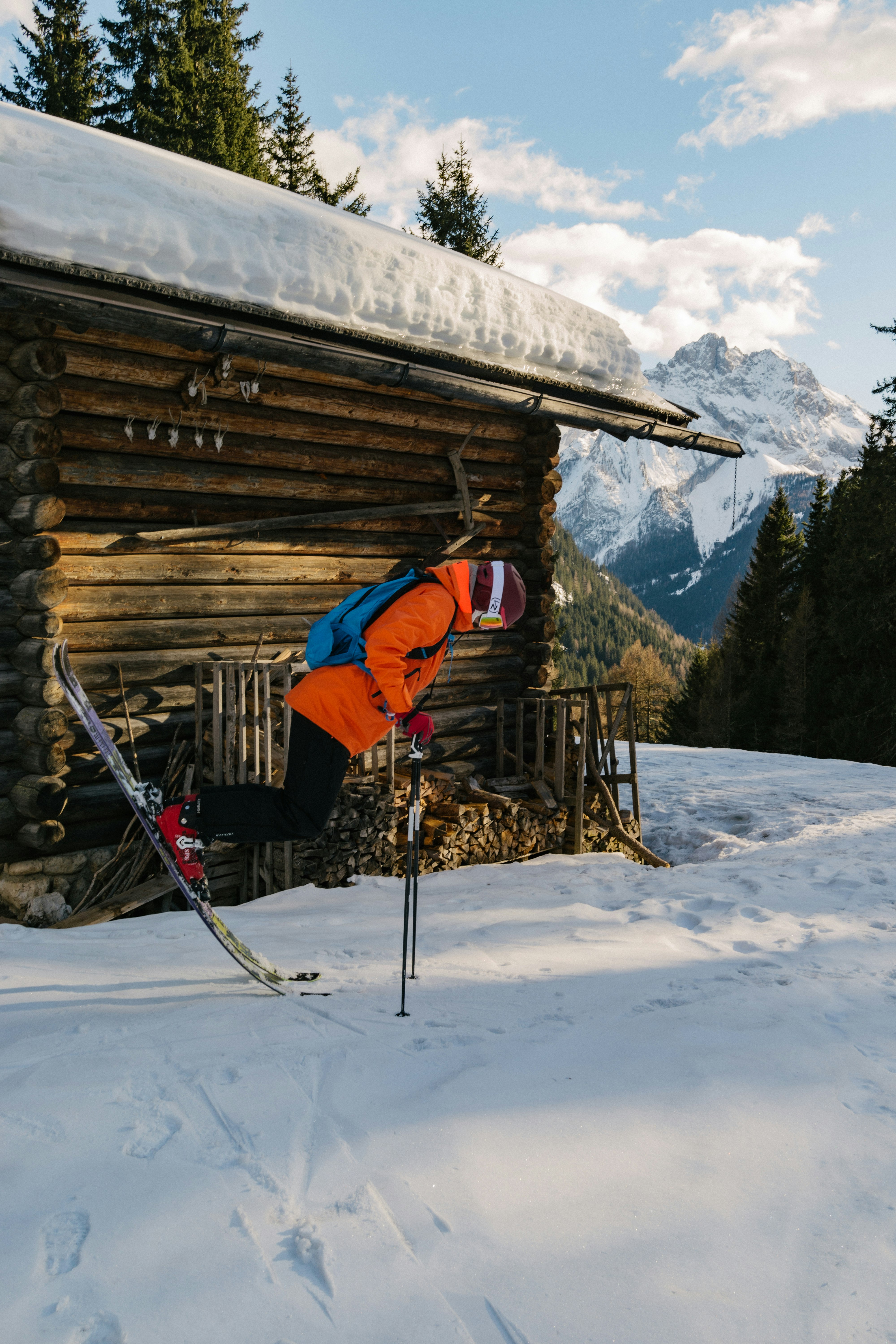 Man in Red ski jacket doing a freestyle ski trik in dolomite Alps.