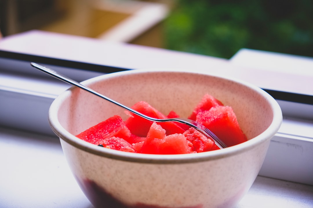 sliced strawberries in white ceramic bowl