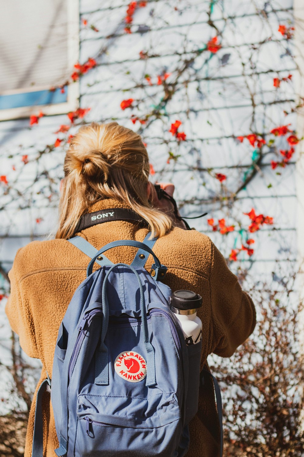 woman in brown coat with brown backpack