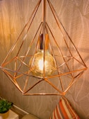 gold pendant lamp turned on near green plant