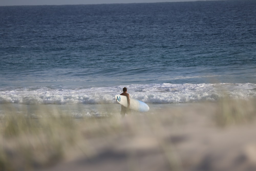 woman in white dress lying on beach shore during daytime