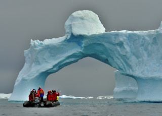 people sitting on ice formation during daytime