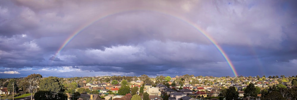 city with high rise buildings under rainbow