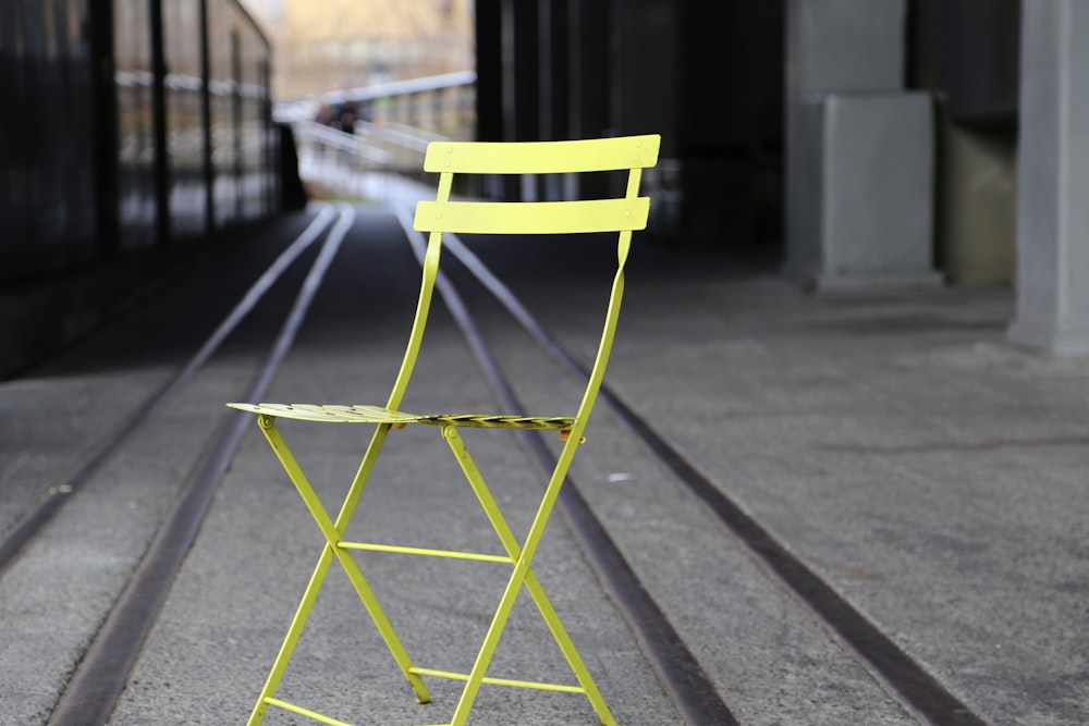 yellow metal chair on gray concrete road during daytime