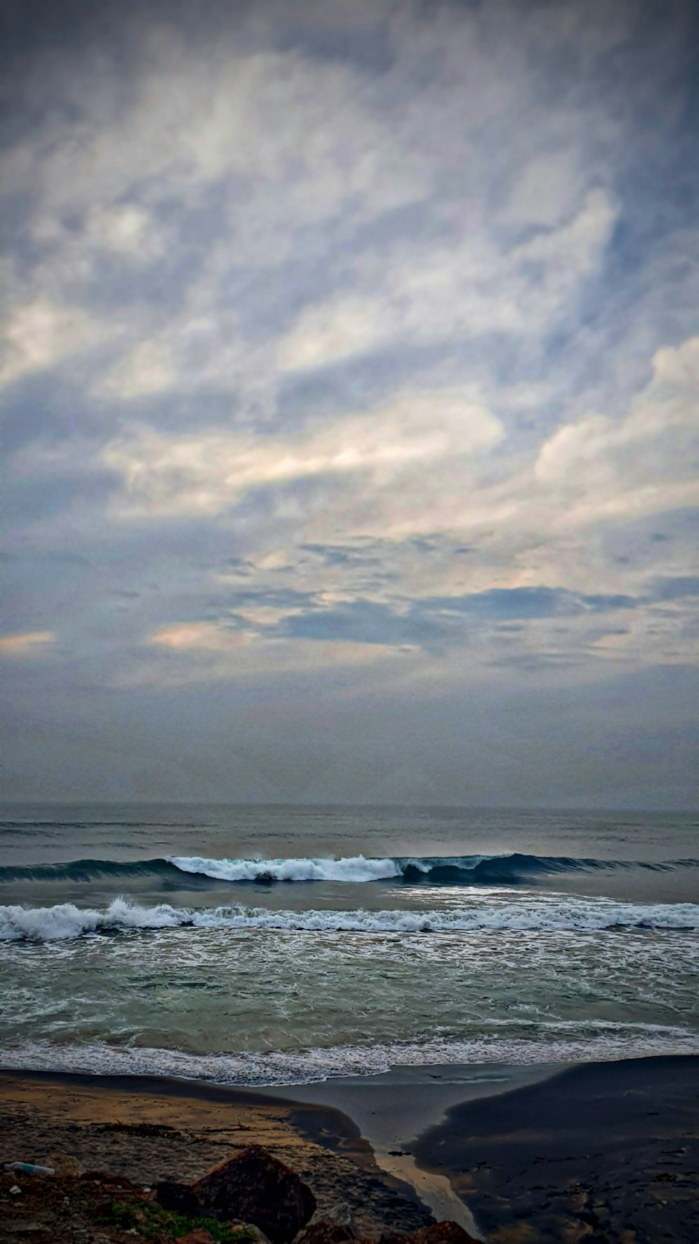 ocean waves under cloudy sky during daytime