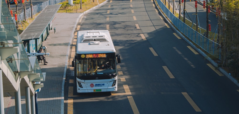 white and blue bus on road during daytime