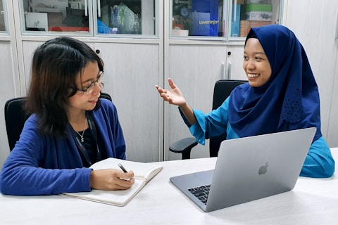 woman in blue robe using macbook