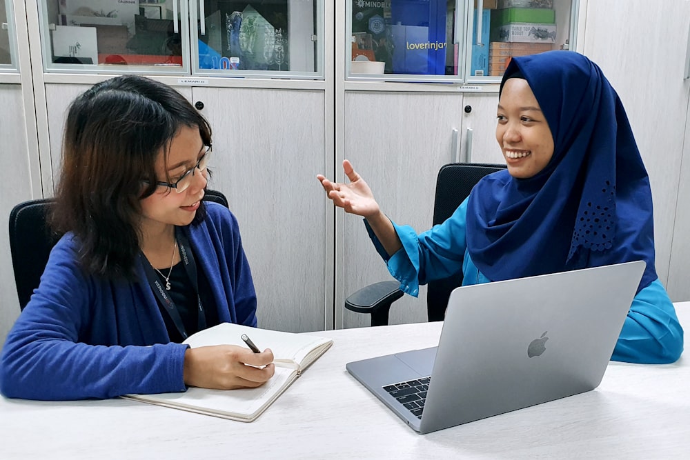 woman in blue robe using macbook