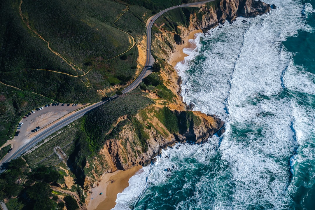 aerial view of road near body of water during daytime