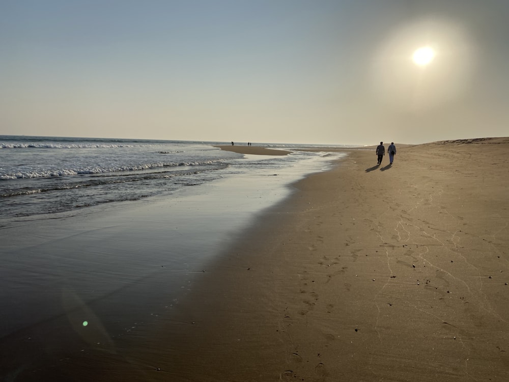 persona che cammina sulla spiaggia durante il giorno