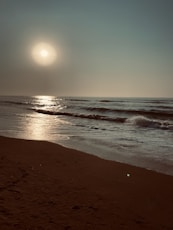 sea waves crashing on shore during sunset