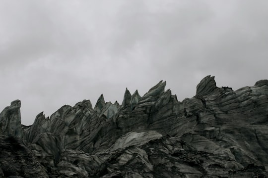 gray rocky mountain under white cloudy sky during daytime in Fox Glacier New Zealand