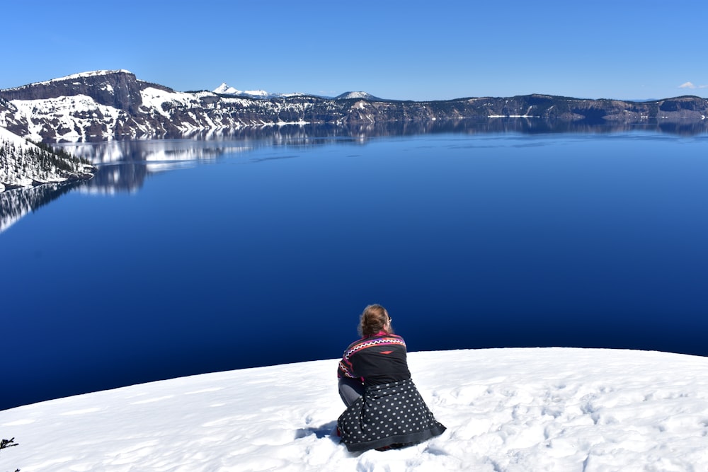 woman in black and white polka dot jacket standing on snow covered ground during daytime