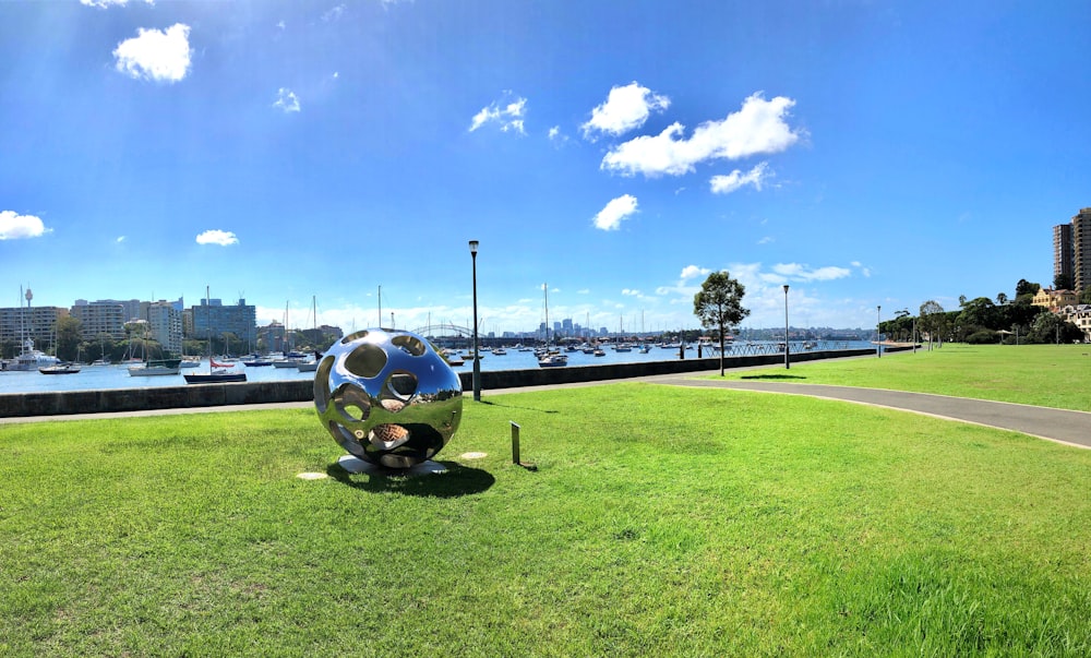 bola de futebol branca e azul no campo de grama verde sob o céu azul durante o dia