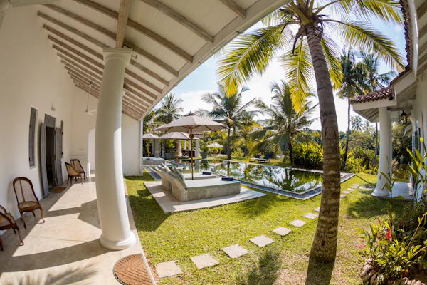 A private villa with a pillared verandah and palm trees in the early morning, southern Sri Lanka