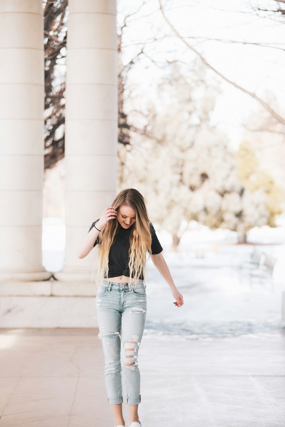 Woman in black long sleeve shirt and blue denim jeans standing near white  concrete building during photo – Free Clothing Image on Unsplash