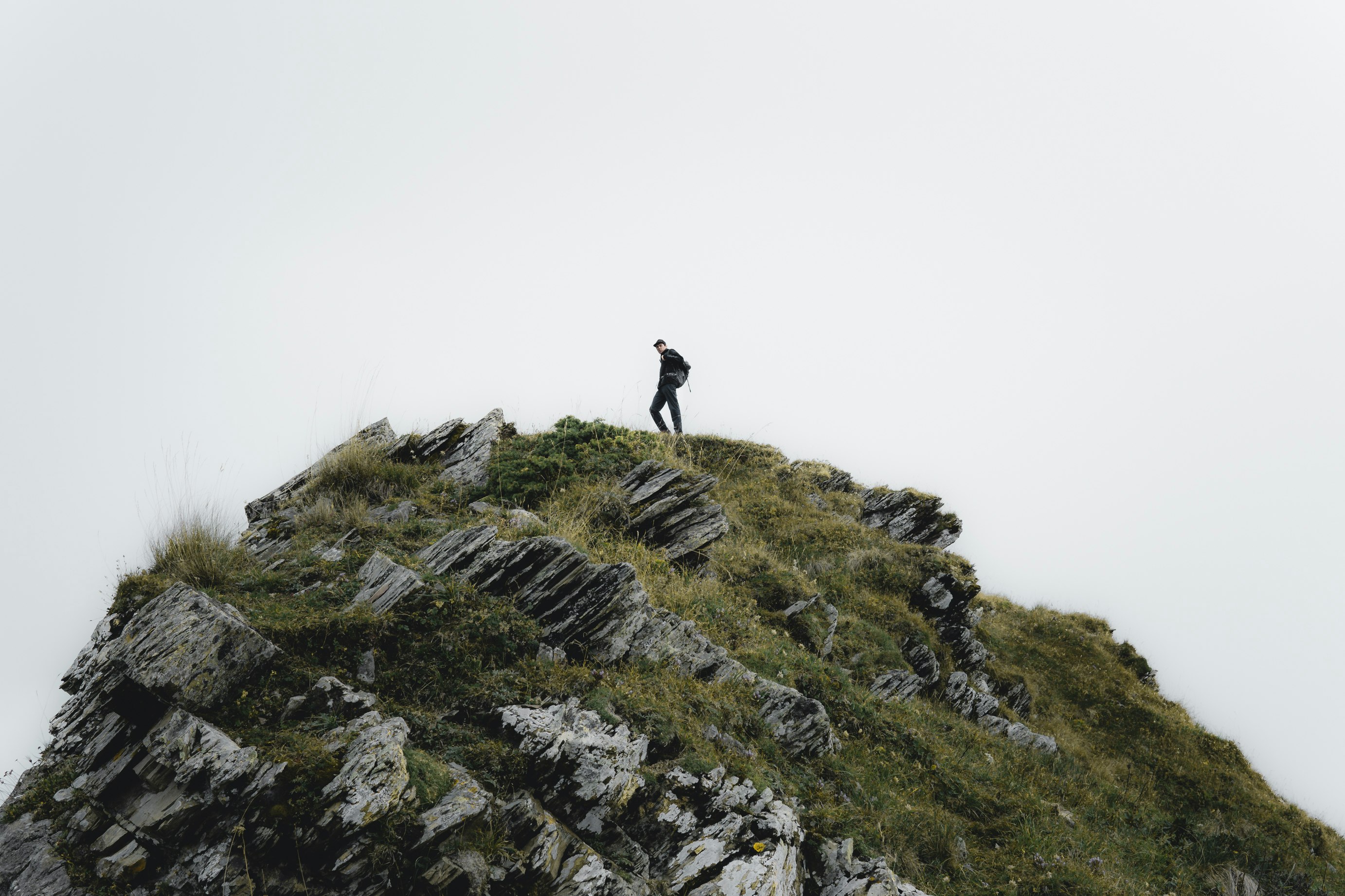 person standing on rocky mountain during daytime