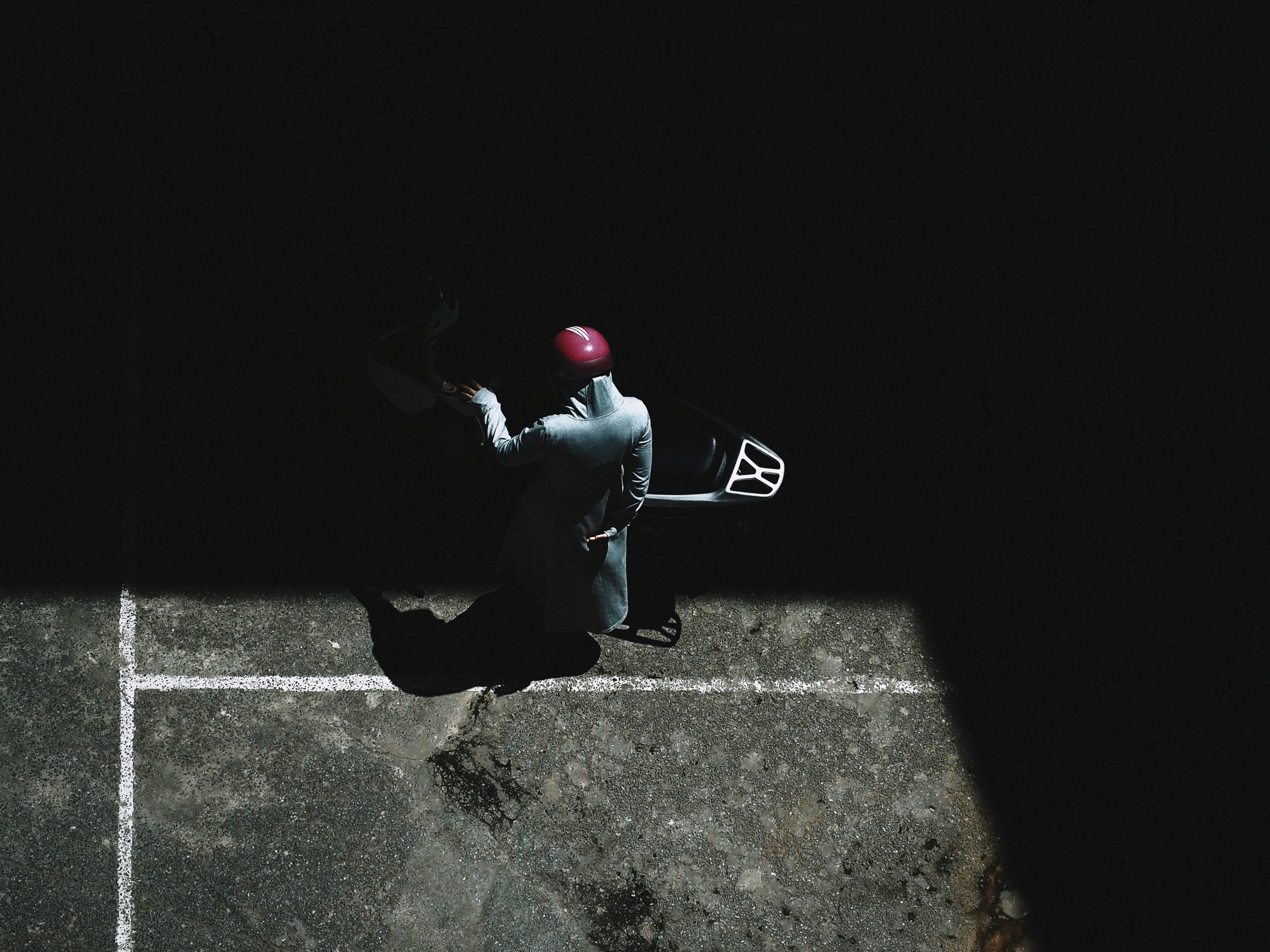man in black jacket and red cap sitting on black chair